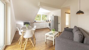 Um apartamento moderno estilo loft com área de refeições, cozinha e sala de estar.