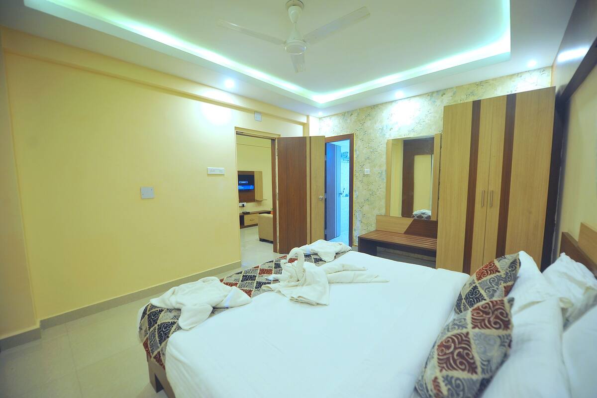 A hotel room with a bed, a wardrobe, a mirror, and a television.