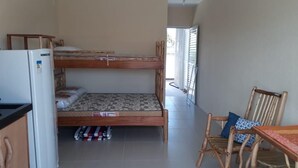 A compact room with a bunk bed, a small table, and a refrigerator.
