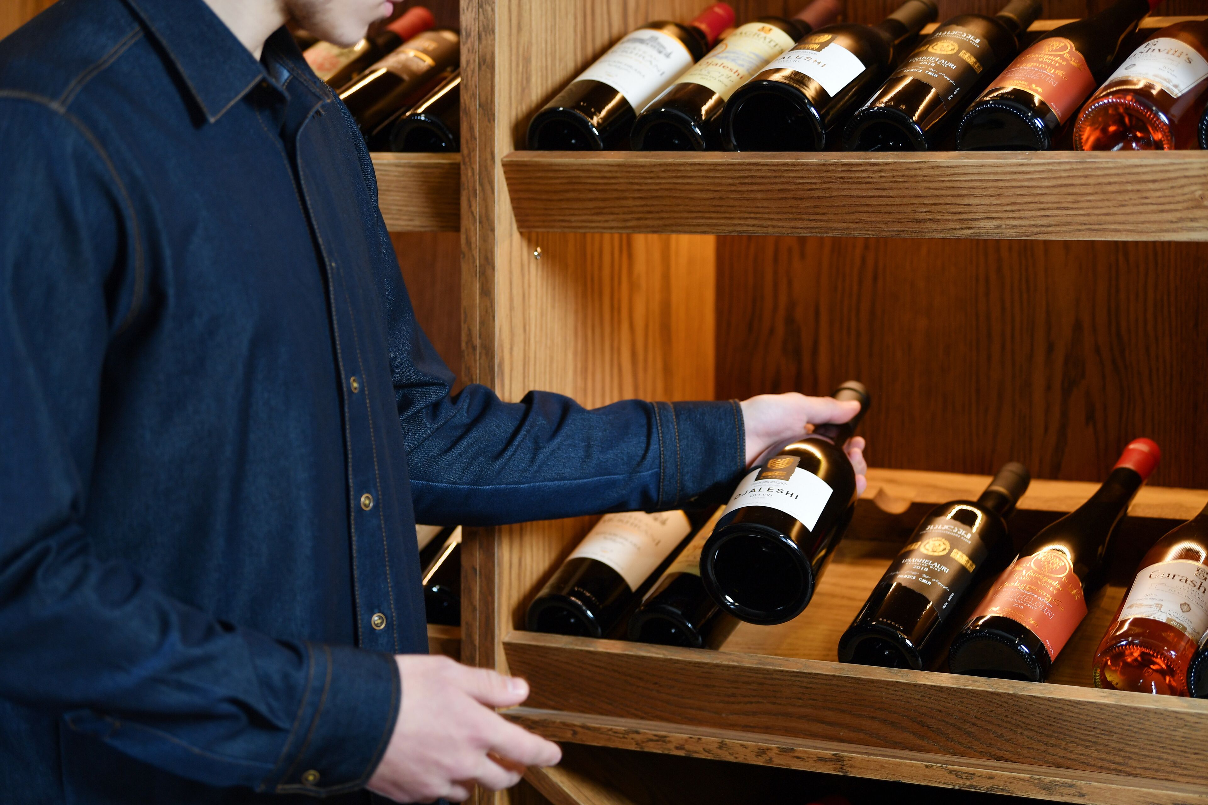 A wooden wine rack with multiple bottles of wine.