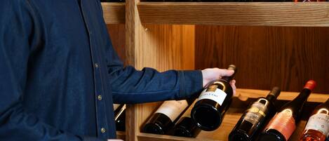 A wooden wine rack with multiple bottles of wine.