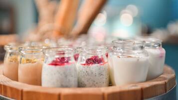 A wooden tray with glass jars containing various food items.