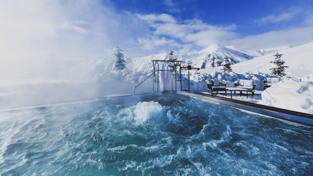 A snow-covered outdoor area with a hot tub, benches, and a metal structure. - Gudauri Lodge (Kazbegi)