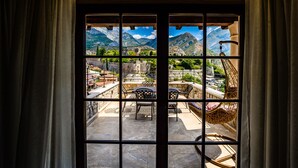 A room with a large window overlooking a mountainous landscape and a patio area with outdoor furniture. - Stara Čaršija Hotel and Spa (Bar)
