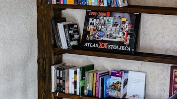 A bookshelf with various books and a book titled "Atlas XX Stojčeć".