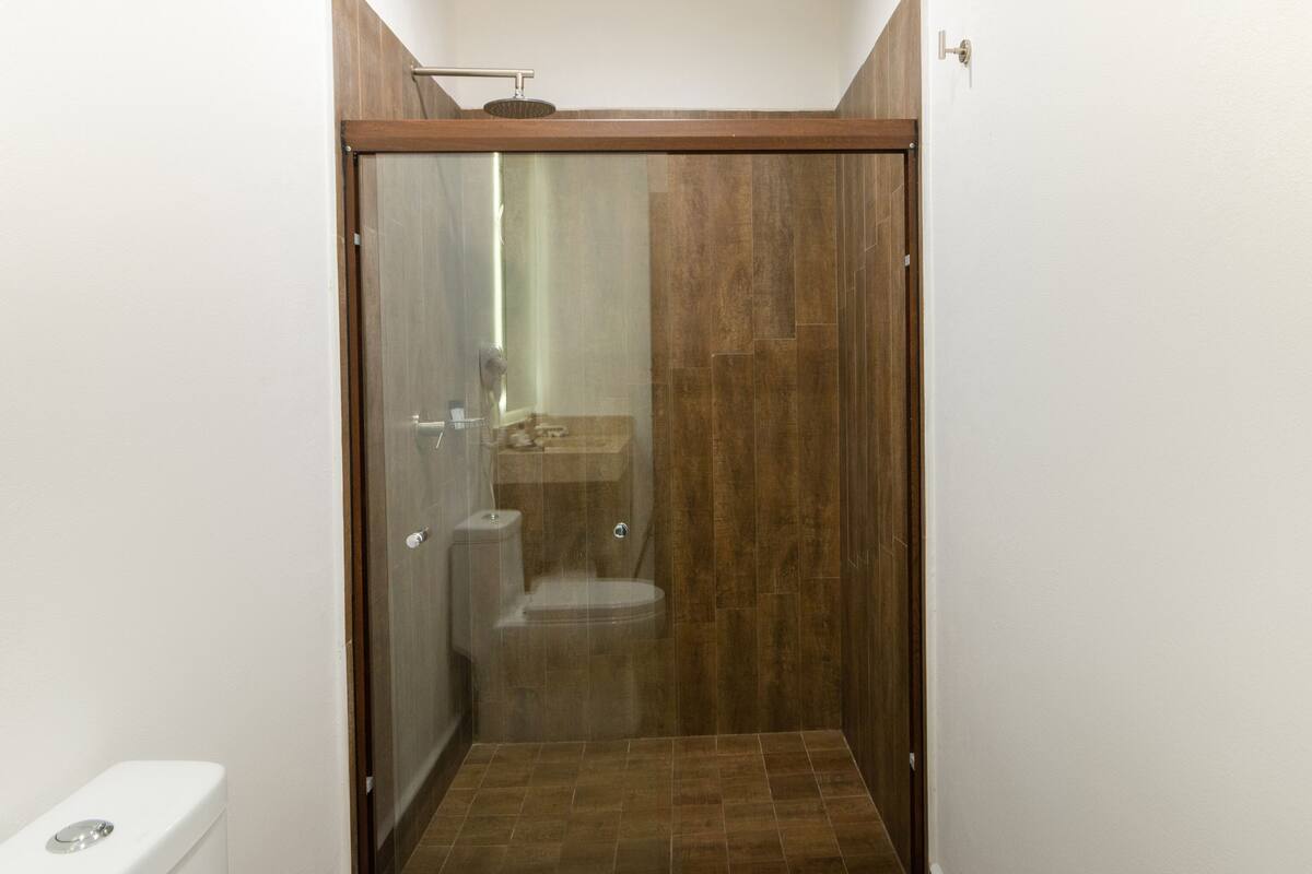 A small, enclosed shower area with a toilet and a sink.