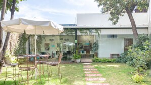 A patio area with outdoor seating, a glass door entrance, and a pathway with motivational words. - Fraga Hotel Boutique (Irapuato)