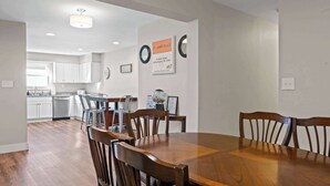 A dining area with a wooden table and chairs, a kitchen in the background, and a sign indicating the location as St. James Place.