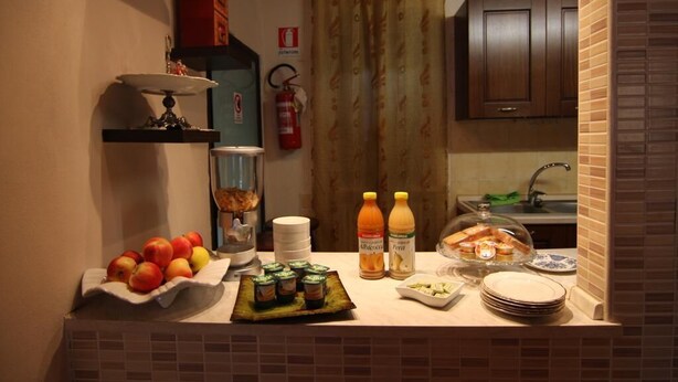 Een keukentafel met fruit, kruiden en een broodmand.