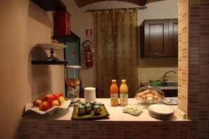 A kitchen counter with fruits, condiments, and a bread basket. - B&B Il Sogno di Maggy (Asti)