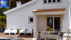 A modern villa with a pool, outdoor seating, and a dining area.