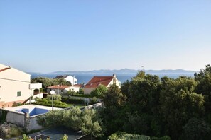 A residential area with houses, a swimming pool, and a view of the sea and mountains. - Apartments Kekic (Zadar)