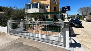 Un edificio de dos plantas con balcón, una entrada con reja y un letrero que dice "PUT BILINE".