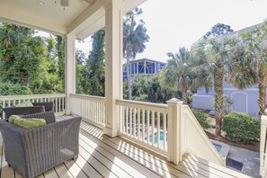 A covered porch with wicker furniture, a pool, and lush greenery. - 3 Bayberry-Recently Updated and 3rd Row Ocean w/ Private HEATED Pool (Hilton Head Island)