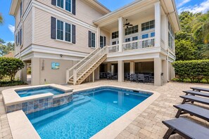 A two-story building with a swimming pool and outdoor seating area.