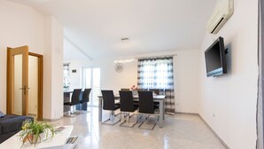 A modern living room with a sofa, a coffee table, and a dining area with chairs and a table. - A comfortable home perfect for relaxing in the green heart of Istria (Bokordici)
