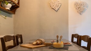 Une table à manger avec une miche de pain, une portion de fromage et une petite assiette de nourriture.