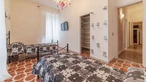 A bedroom with a bed, a chest of drawers, a wardrobe, and a chandelier. - GuestHost - Testaccio Art & Design Flat BOOK NOW! (Roma)