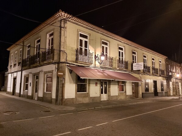 A two-story building with a sign indicating it is a pension.