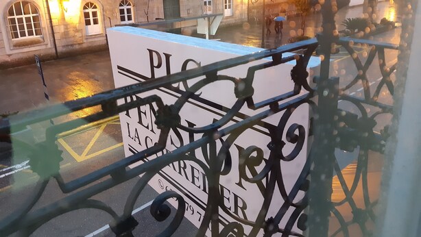 Vista de un edificio con un cartel grande que dice 'PLOVER' y una barandilla metálica al frente.