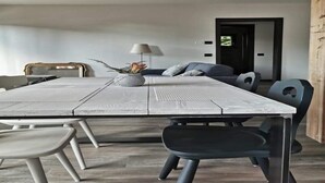 A dining area with a rustic wooden table, modern chairs, and a decorative centerpiece. - Apartment "Casa Ester" 4 people (Baselga di Pinè, Italia)