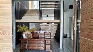 A modern interior with a wooden staircase, a wooden chest of drawers, and a welcome sign. - Apartment "Casa Ester" 4 people (Baselga di Pinè, Italia)