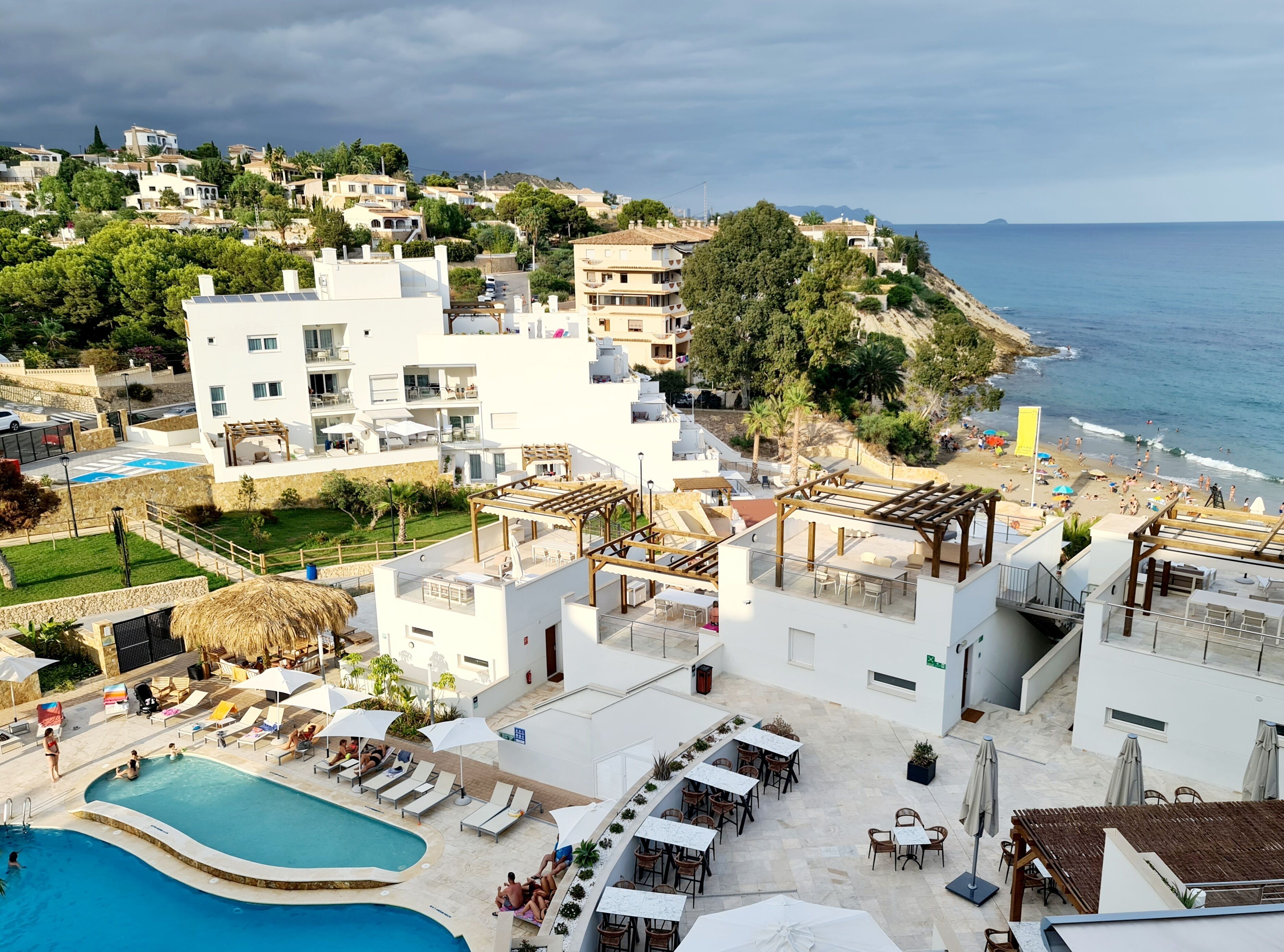 Ein Resort mit Pool, Sitzgelegenheiten im Freien und Meerblick.