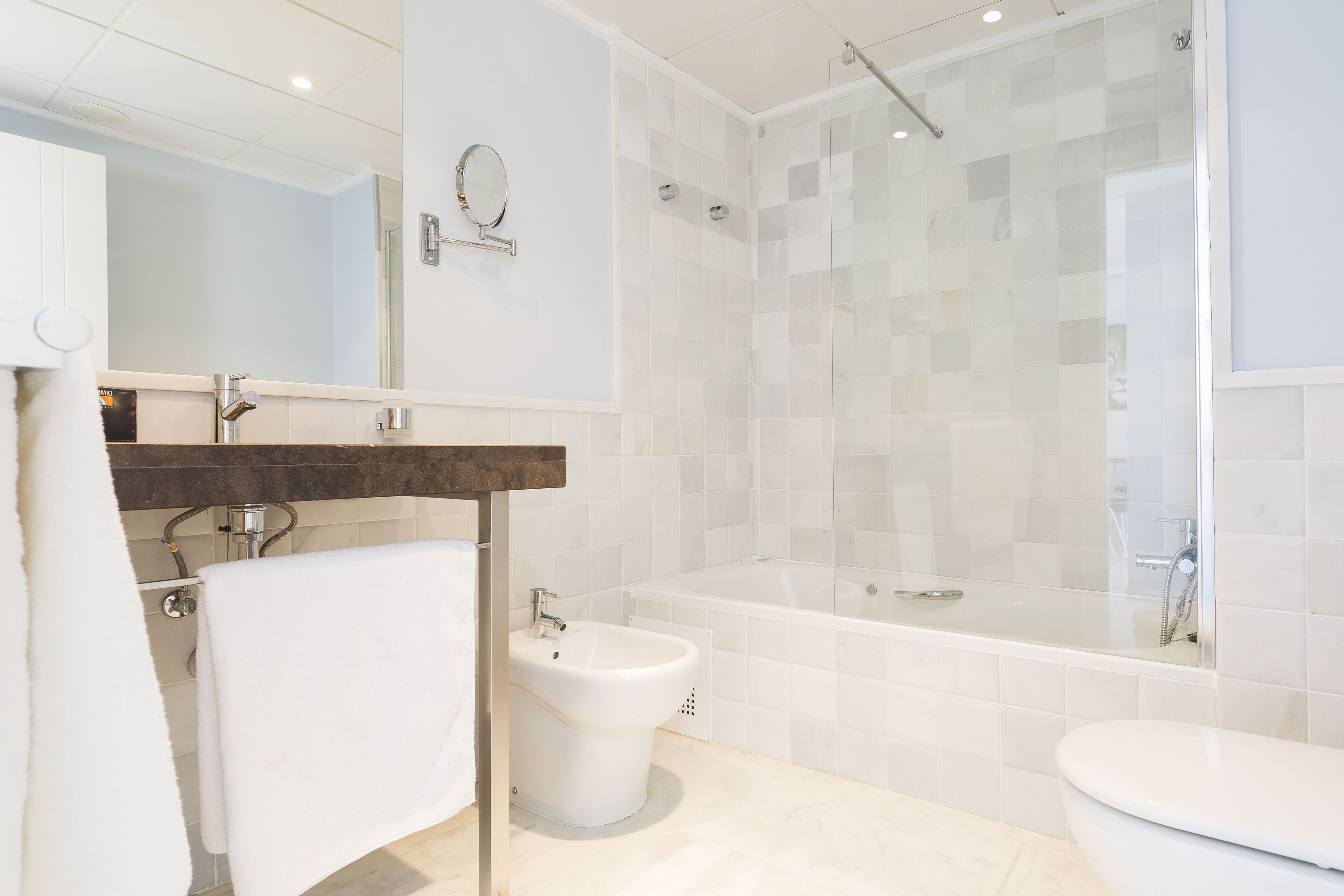 A modern bathroom with a bathtub, a shower, and a toilet.