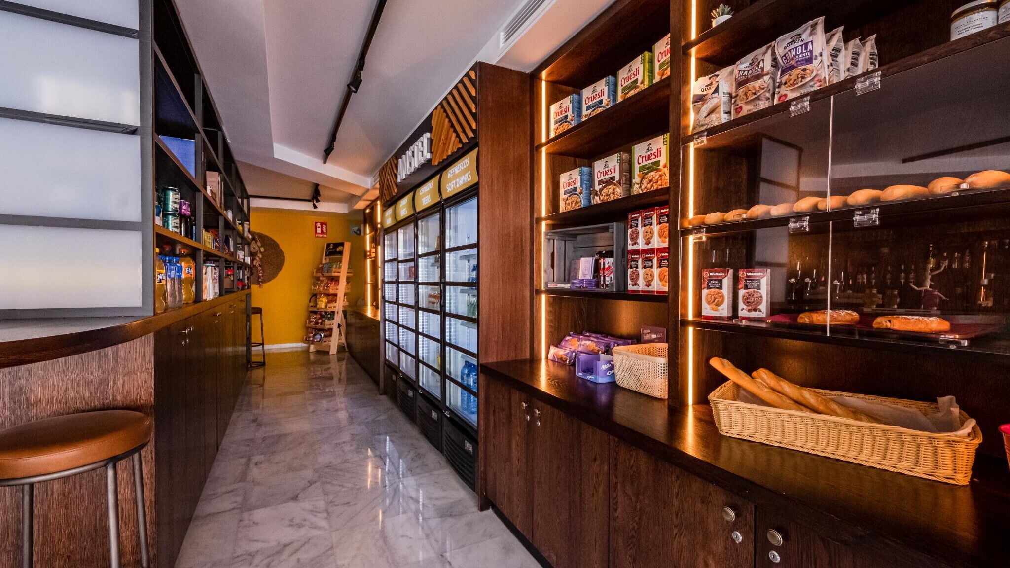 Una sección de panadería con estantes repletos de productos horneados y bocadillos envasados.
