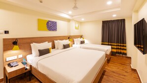 A hotel room with two beds, a wooden headboard, a nightstand with a lamp, and a large window with curtains. - IStayHotels  Jubilee Hills  Hyderabad (Hyderabad)