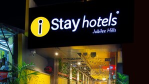 A Stay Hotels Jubilee Hills entrance with a glass facade, a staircase leading inside, and potted plants in the foreground. - IStayHotels  Jubilee Hills  Hyderabad (Hyderabad)