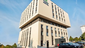 A modern hotel building with a flat facade, multiple windows, and a visible garage entrance. - Campanile Duisburg City (Duisburg)