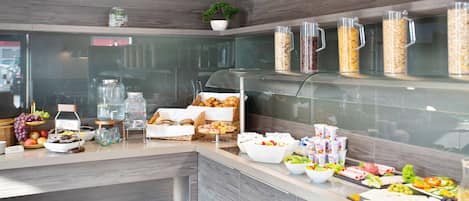 Un bufé de desayuno con diferentes alimentos y bebidas.