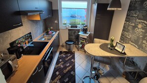 A compact kitchen with a window, a coffee machine, and a chalkboard menu. - Luxurious apartment in the beautiful Elbmarschland (Tespe)