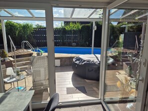 A sunlit patio with a pool, outdoor seating, and a covered grill area. - Luxurious apartment in the beautiful Elbmarschland (Tespe)