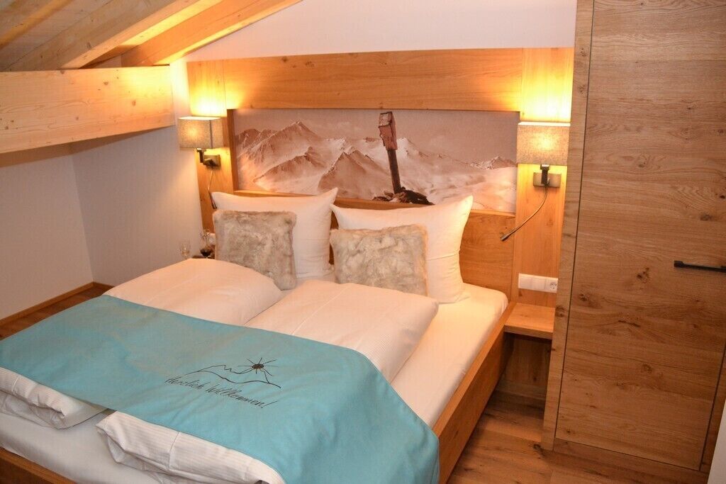 A bedroom with a wooden headboard, two bedside tables, and a bed with a blue blanket.