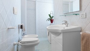 Une salle de bain moderne équipée de toilettes, d’un lavabo et d’une douche.