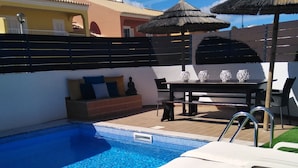 Una piscina al aire libre, tumbonas