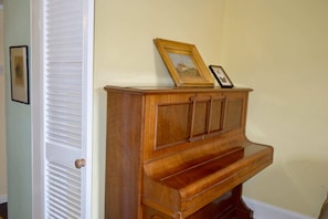 Enjoy relaxing moments by the piano, surrounded by framed artwork.