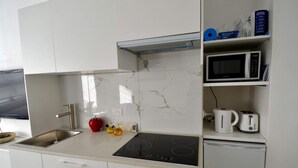 Eine moderne Küche mit integriertem Mikrowellenherd, Toaster und Kaffeemaschine.