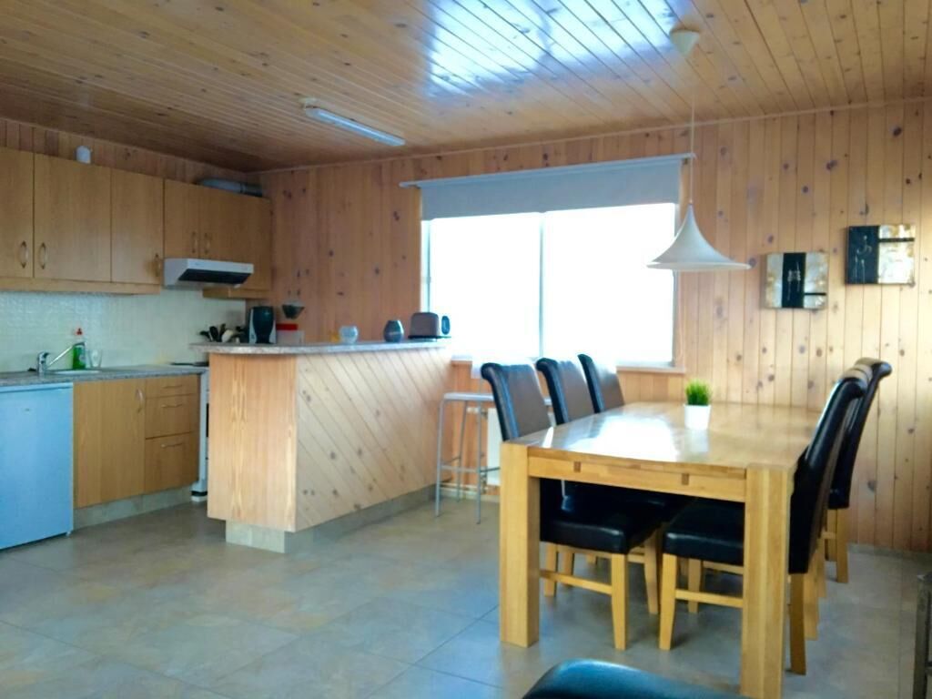 Interior em madeira com cozinha e sala de jantar.