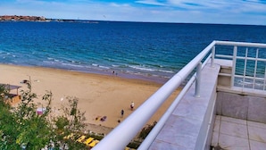 Une plage offrant une vue dégagée sur la mer et sur une côte lointaine.