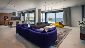 Una sala de estar moderna con un sofá grande, una mesa de centro y vista al mar.