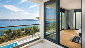 Un balcón con vista al mar y una piscina.