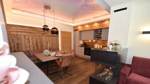 A modern kitchen with wooden cabinetry and a built-in stove. - Deluxe Suite Goldreh - SKI in/SKI out, Sauna-Jacuzzi - by "wachterhof" (Kaltenbach)