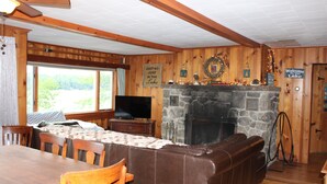 A wooden interior with a stone fireplace, a television, and a sign reading "Welcome to the Lake." - Waterfront House on Winnipesaukee w Private Dock , Sleeps 11 & Dogs Welcome! (Moultonborough)