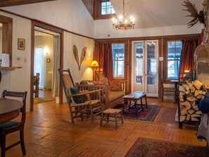 Uma sala de estar aconchegante com móveis de madeira, lareira e um candelabro.