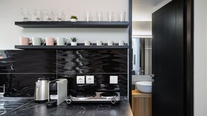 Eine moderne Küche mit schwarzem Arbeitsplatz, Edelstahlgeräten und einer schwarzen Spritzschutzwand.