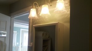A bathroom with a mirror, a towel rack, and a shower curtain. - Private Suite (Paso Robles)