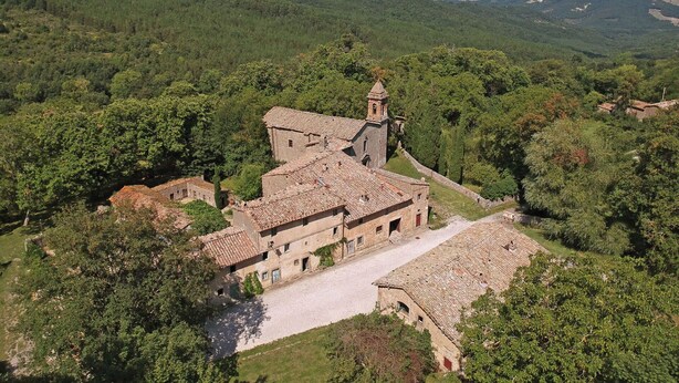 A historic stone building with a bell tower, surrounded by lush greenery and hills. - Wonderful  villa for 5 people with pool, WIFI, TV and patio (Vivo D'orcia)